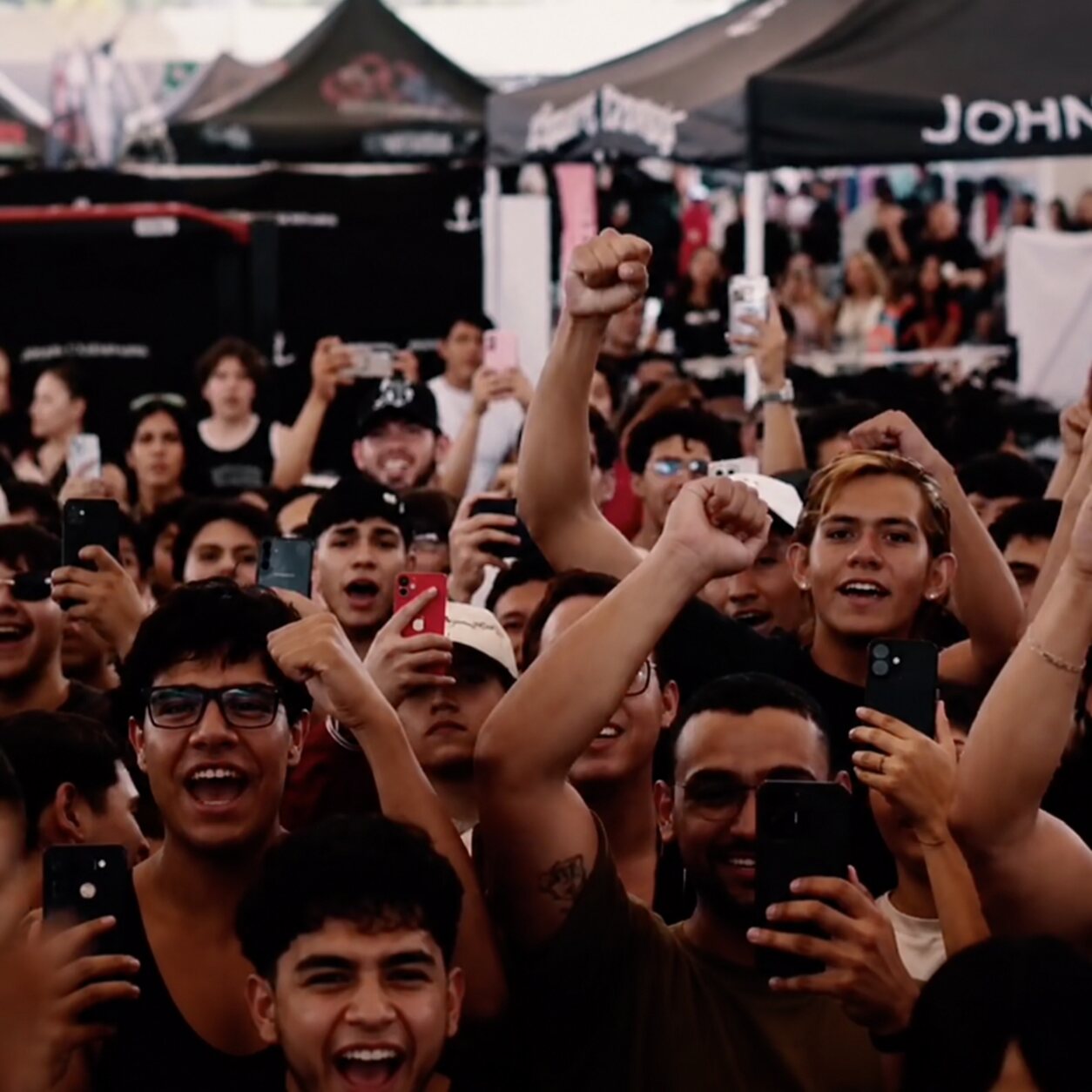 Fans cheering and raising their fists at the UnKrowned King World Tour in Mexico